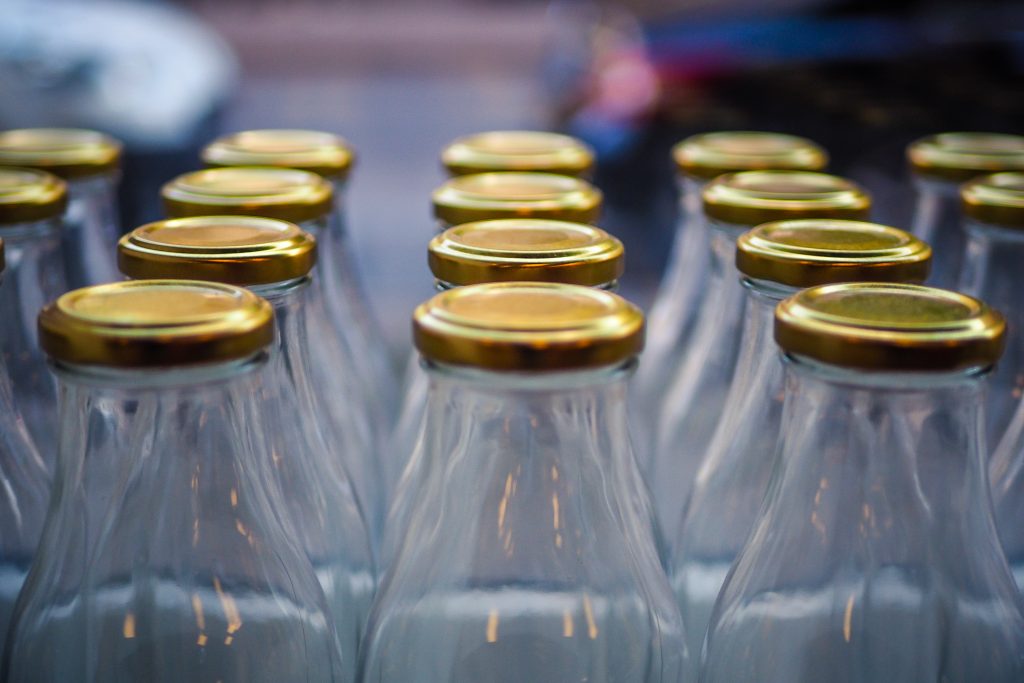 Glass bottles with metal caps in the zero waste shop window. Zero waste concept